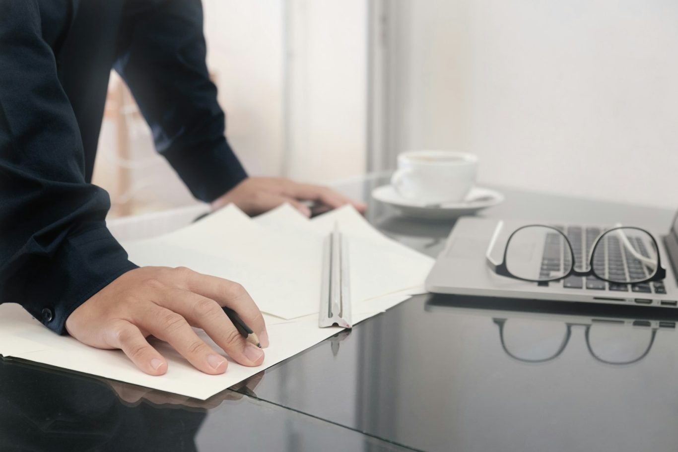 Konsulttjänster & projektering En hand skriver i en anteckningsbok bredvid en laptop och en kopp kaffe.